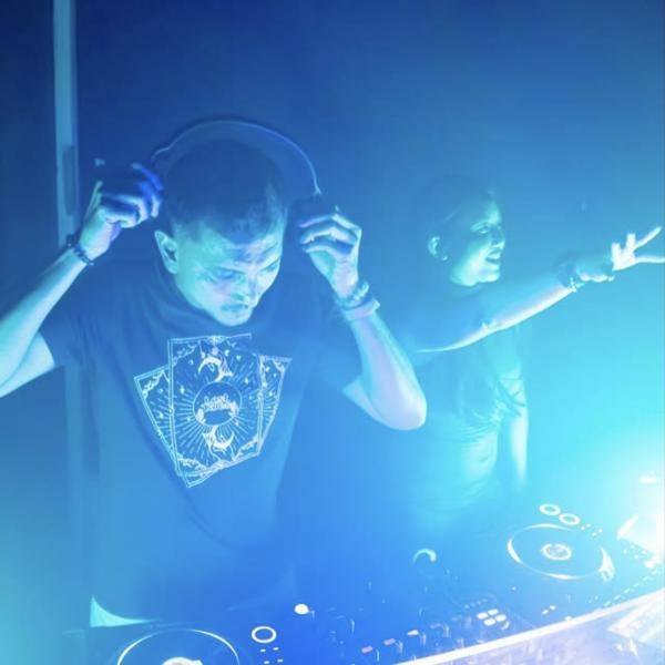 Two DJs playing under blue light